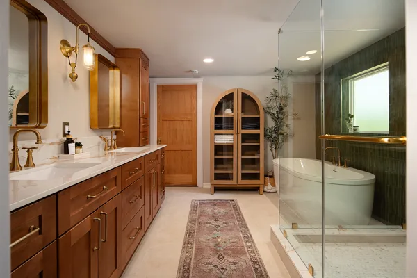 Finished award-winning MUSE bathroom with wood vanity, brass fixtures and glass-enclosed shower
